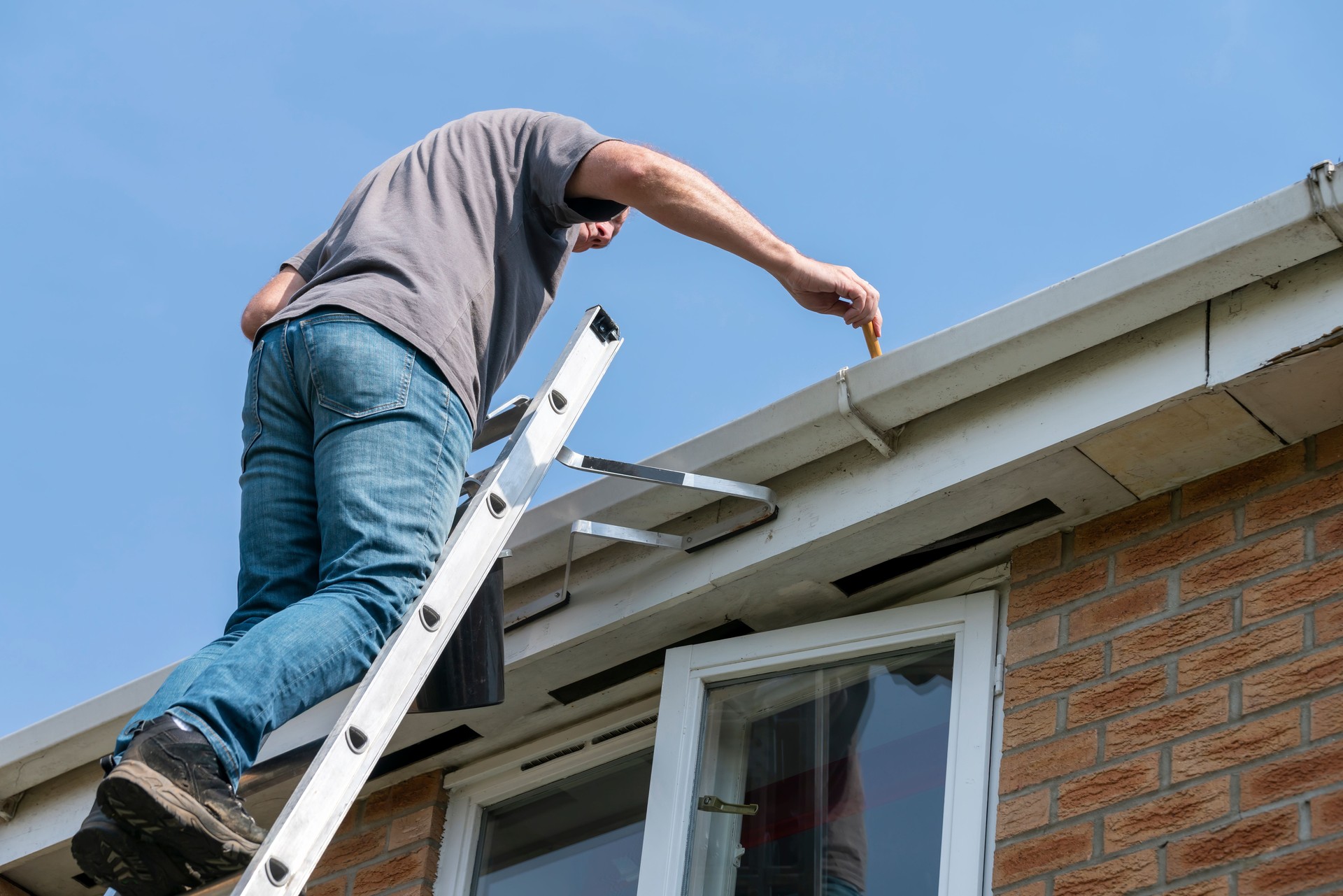 Senior man cleaning gutters